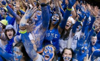 students with blue face paint laughing and cheering