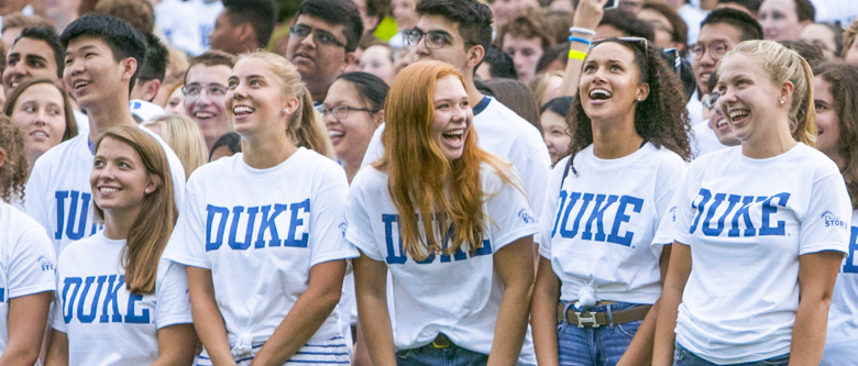 duke freshmen smiling and laughin with duke t-shirts in a crowd
