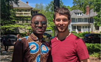 Duke undergraduate student Andrew Carlins posing with refugee Faustin