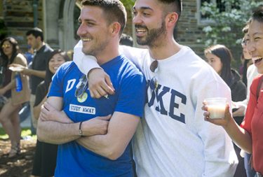 two students laughing and looking away on a field