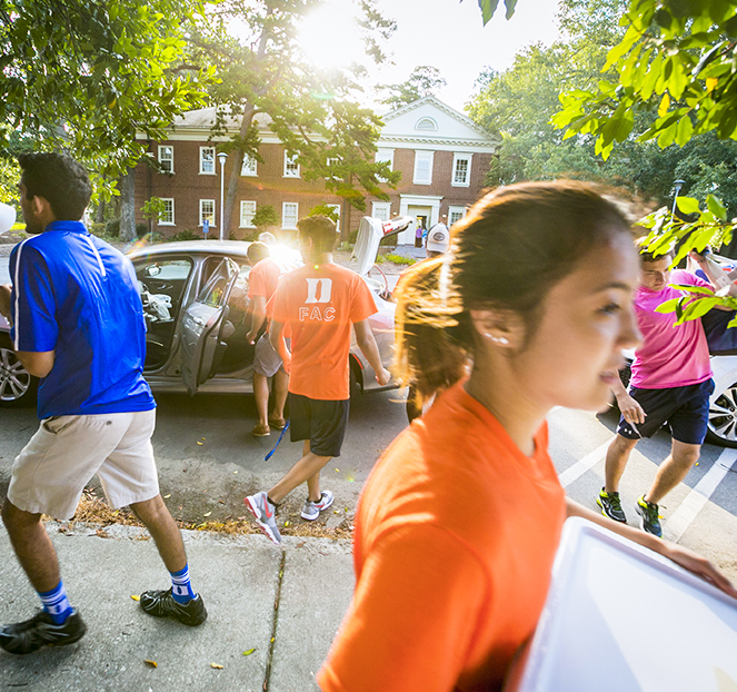 student movers walking on sidewalk on a sunny summer day