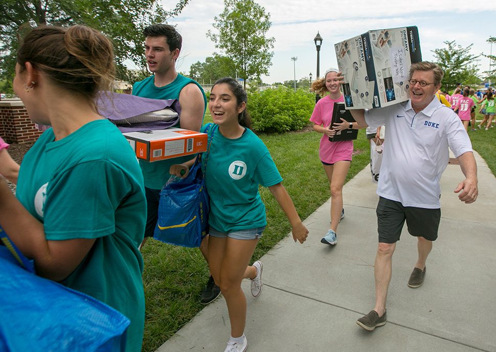Four Duke students and President Price help first year students move into their residence halls