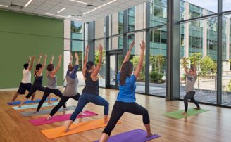 students doing a yoga pose on yoga mats in a room in the wellness center